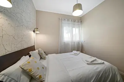 a bedroom with a bed with white sheets and a window at New Apartments Luiz I Bridge by Amber Star Rent in Vila Nova de Gaia