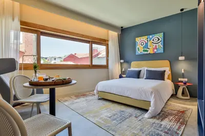 a bedroom with a bed and a table and a window at Aspasios Bonjardim Apartments in Porto