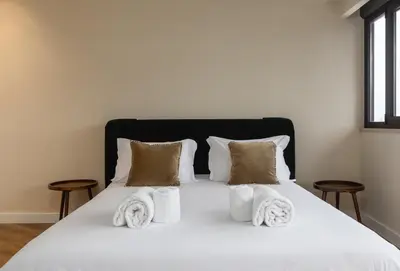 a bedroom with a white bed with towels on it at Aspasios Bonjardim Apartments in Porto