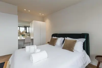 a bedroom with a large white bed with pillows at Aspasios Bonjardim Apartments in Porto