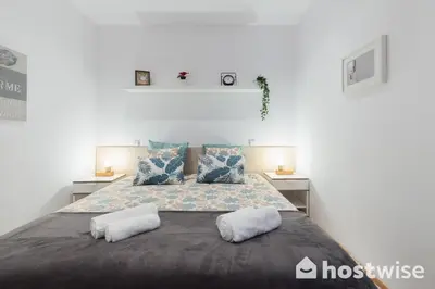 a bedroom with a large bed with two pillows at Host Wise - Colorful Fresh Flats - Batalha in Porto