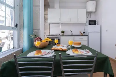a kitchen with a table with food and orange juice at Host Wise - Colorful Fresh Flats - Batalha in Porto