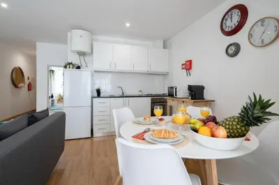 a kitchen and a living room with a table with fruit on it at Host Wise - Colorful Fresh Flats - Batalha in Porto