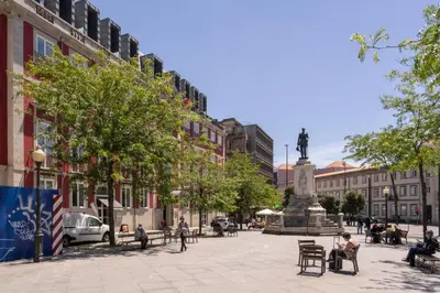 a city square with a statue in the middle at Host Wise - Colorful Fresh Flats - Batalha in Porto