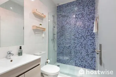 a bathroom with a toilet and a glass shower at Host Wise - Comfortable Stunning Flats - City Center in Porto