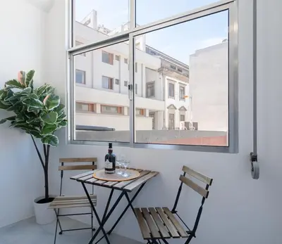 a table and chairs in a room with a window at Host Wise - Comfortable Stunning Flats - City Center in Porto