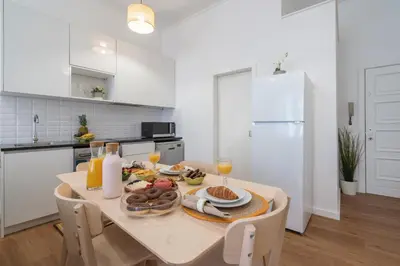 a white kitchen with a table with food on it at Host Wise - Comfortable Stunning Flats - City Center in Porto
