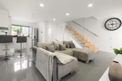 a living room with a couch and a staircase at Host Wise - Spacious Noble Apartaments Ace Location in Porto