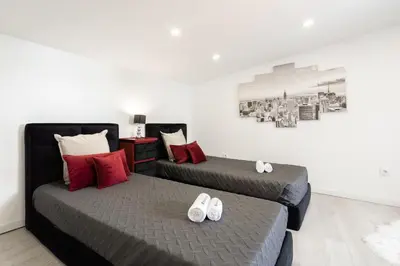 two beds in a room with shoes on them at Host Wise - Spacious Noble Apartaments Ace Location in Porto