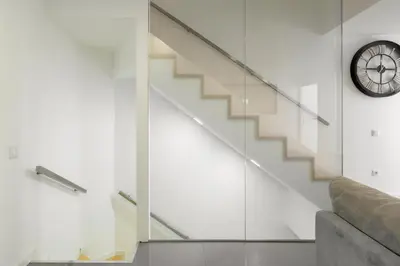 a glass staircase with a clock and a couch at Host Wise - Spacious Noble Apartaments Ace Location in Porto