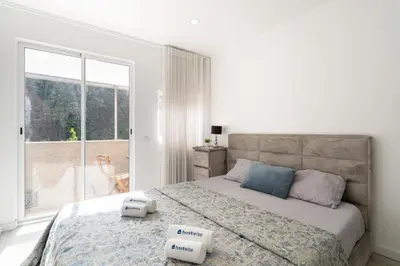 a bedroom with a bed and a large window at Host Wise - Spacious Noble Apartaments Ace Location in Porto