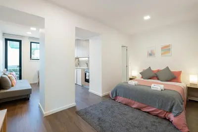 a bedroom with a bed and a living room at Host Wise - Modern Studios with Terrace - Walk Everywhere in Porto