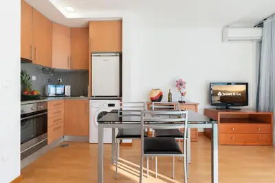 a kitchen with a table and chairs and a television at Host Wise - Bright Quiet Flats - Prime Location in Porto