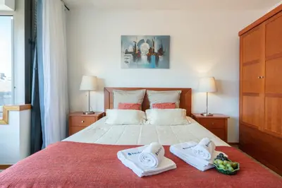 a bedroom with a bed with towels and fruit on it at Host Wise - Bright Quiet Flats - Prime Location in Porto