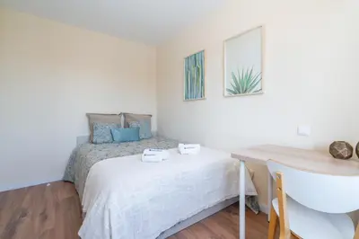 a small bedroom with a bed and a desk at Host Wise - Fantastic Contemporary Flat w Balcony in Porto