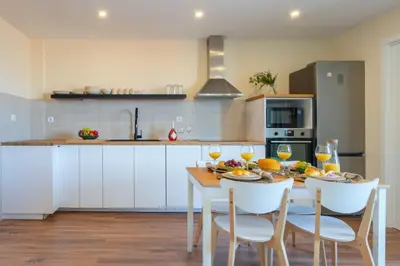 a kitchen with a table and chairs with wine glasses at Host Wise - Fantastic Contemporary Flat w Balcony in Porto