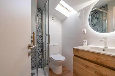 a bathroom with a toilet and a sink and a mirror at Host Wise - Fantastic Contemporary Flat w Balcony in Porto