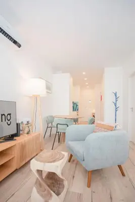a living room with a blue couch and a tv at Liiiving in Porto - Urban Art Apartment in Porto