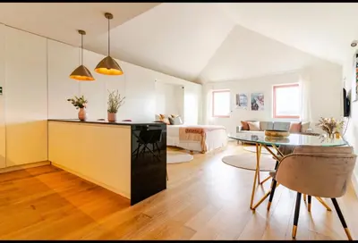 a kitchen and living room with a table and a couch at Fontainhas Hidden Gem in Porto