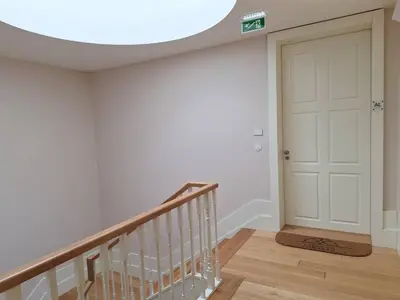 a white hallway with a white door and a staircase at Fontainhas Hidden Gem in Porto
