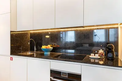 a kitchen with white cabinets and a bowl of fruit on the counter at Fontainhas Hidden Gem in Porto