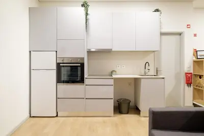 a kitchen with white cabinets and a sink at Dennis Family Friendly House by RDC in Porto