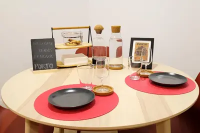 a table with two black plates and wine glasses at Dennis Family Friendly House by RDC in Porto