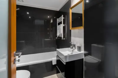 a black bathroom with a sink and a toilet at Host Wise - Bright Fresh Flat with Garage - Marquês in Porto