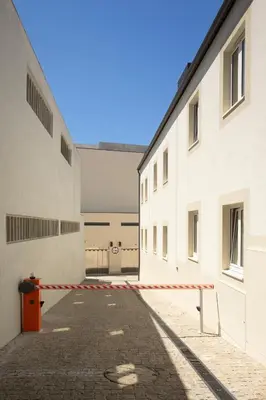 an empty alley between two buildings with a red and white barrier at My Home is Yours in Porto