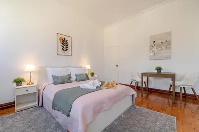 a white bedroom with a large bed with a table at Host Wise - Classy Amazing Flats in Porto