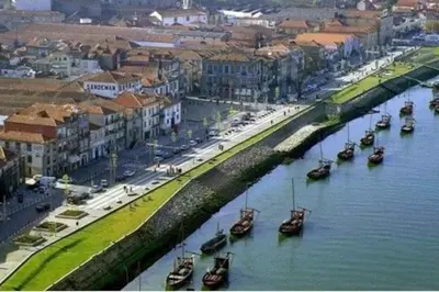 a group of boats in a river next to a city at Loft in the historic center of Oporto downtown in Porto