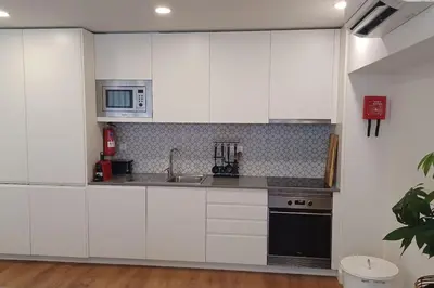 a kitchen with white cabinets and a sink and a microwave at A H - Apartment Oporto Downtown in Porto