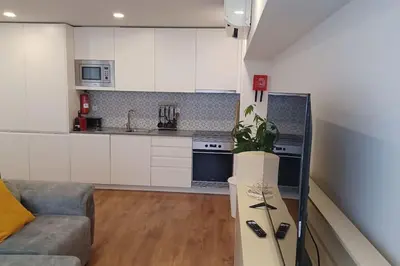 a living room with a couch and a kitchen at A H - Apartment Oporto Downtown in Porto