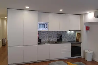 a kitchen with white cabinets and a microwave at A H - Apartment Oporto Downtown in Porto
