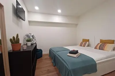 a bedroom with a bed and a desk and a tv at A H - Apartment Oporto Downtown in Porto
