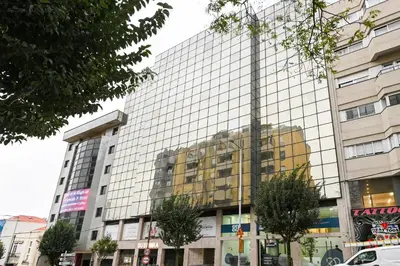 a tall glass building with a reflection of a building at Julio Dinis Porto Secret Retreat - by Guest SPA in Porto
