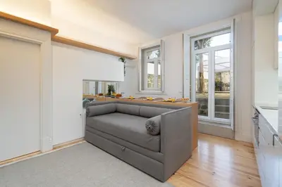 a living room with a couch and windows at Host Wise - Refreshing Cozy Flat - Garden & Terrace in Porto