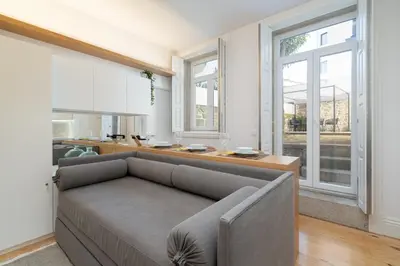 a living room with a couch and a kitchen at Host Wise - Refreshing Cozy Flat - Garden & Terrace in Porto