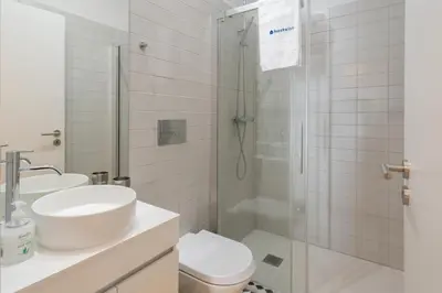 a white bathroom with a sink and a shower at Host Wise - Refreshing Cozy Flat - Garden & Terrace in Porto