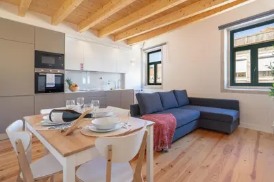 a living room with a table and a blue couch at Host Wise - Lovely & Cozy Duplex Flat in Porto