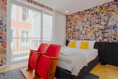 a bedroom with a bed and two red chairs at Theater Studio in Porto