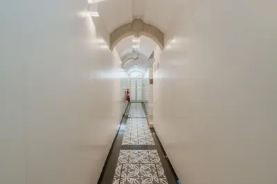 a hallway with white walls and a person in the distance at Theater Studio in Porto