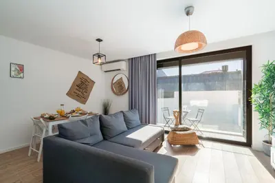 a living room with a blue couch and a large window at Host Wise - Charming Welcoming Flat - Centrally Located in Porto