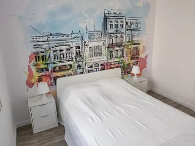 a bedroom with a white bed and a painting on the wall at OLOPO Hostel in Porto