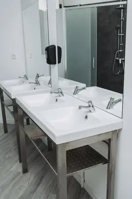 a bathroom with three sinks and a mirror at OLOPO Hostel in Porto