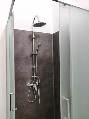 a shower with a shower head in a bathroom at OLOPO Hostel in Porto