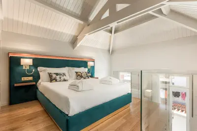 a bedroom with a large bed with a blue headboard at Ribeira Douro Hotel in Porto