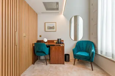 a room with a desk and two blue chairs at Ribeira Douro Hotel in Porto