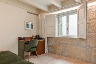 a bedroom with a desk and a window at Ribeira Douro Hotel in Porto
