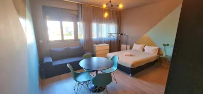 a small bedroom with a bed and a table and chairs at Dragon Studio in Porto